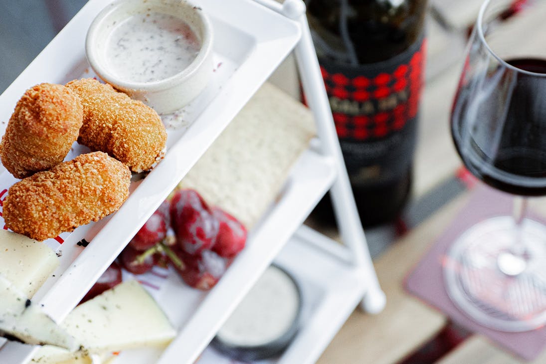 a tower of cheesy snacks and a glass of wine